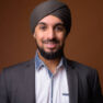 Studio shot of young bearded Indian businessman wearing suit and turban against colored background horizontal shot
